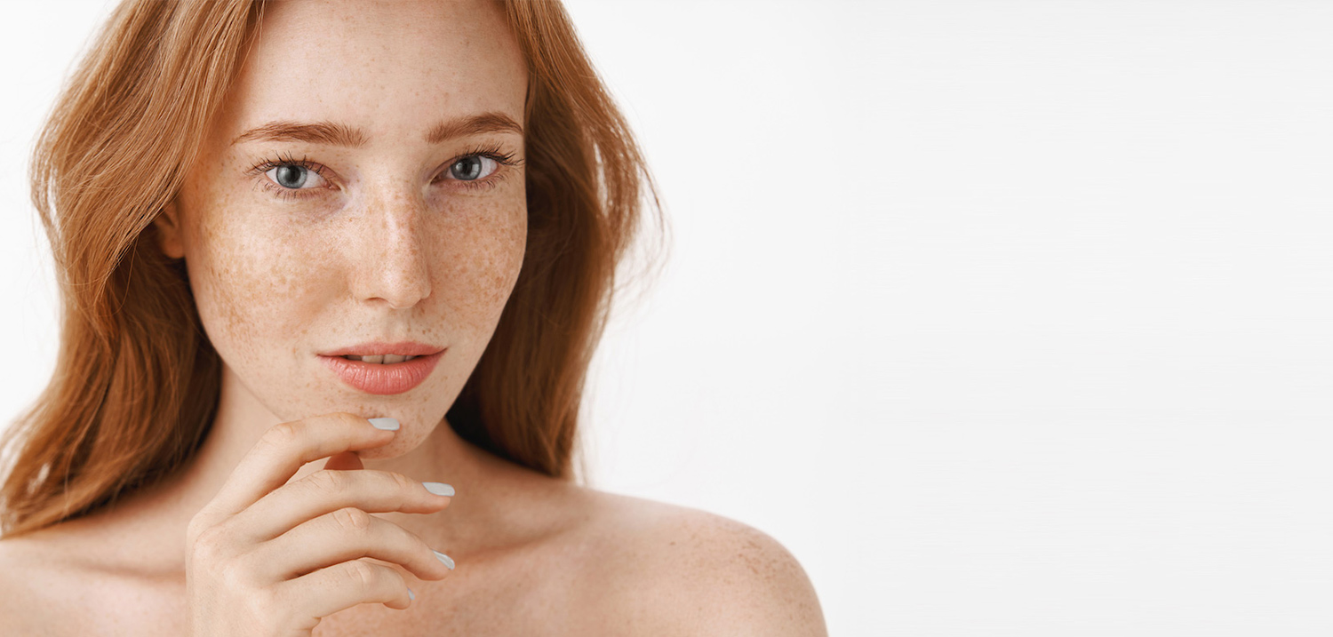 beautiful-feminine-and-attractive-woman-with-natural-red-hair-and-freckles-on-face-and-body-touching-chin-gently-with-fingers-and-gazing-sensual-and-relaxed-taking-care-of-beauty-and-skin